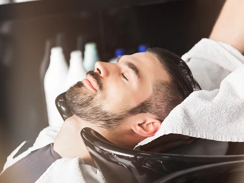 Fryzjerka myje mężczyźnie głowę